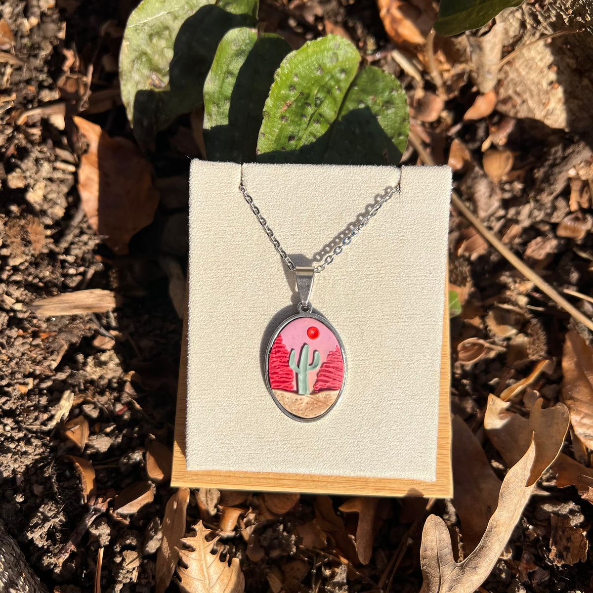 Necklace with a pendant featuring a cactus in desert design on a natural background