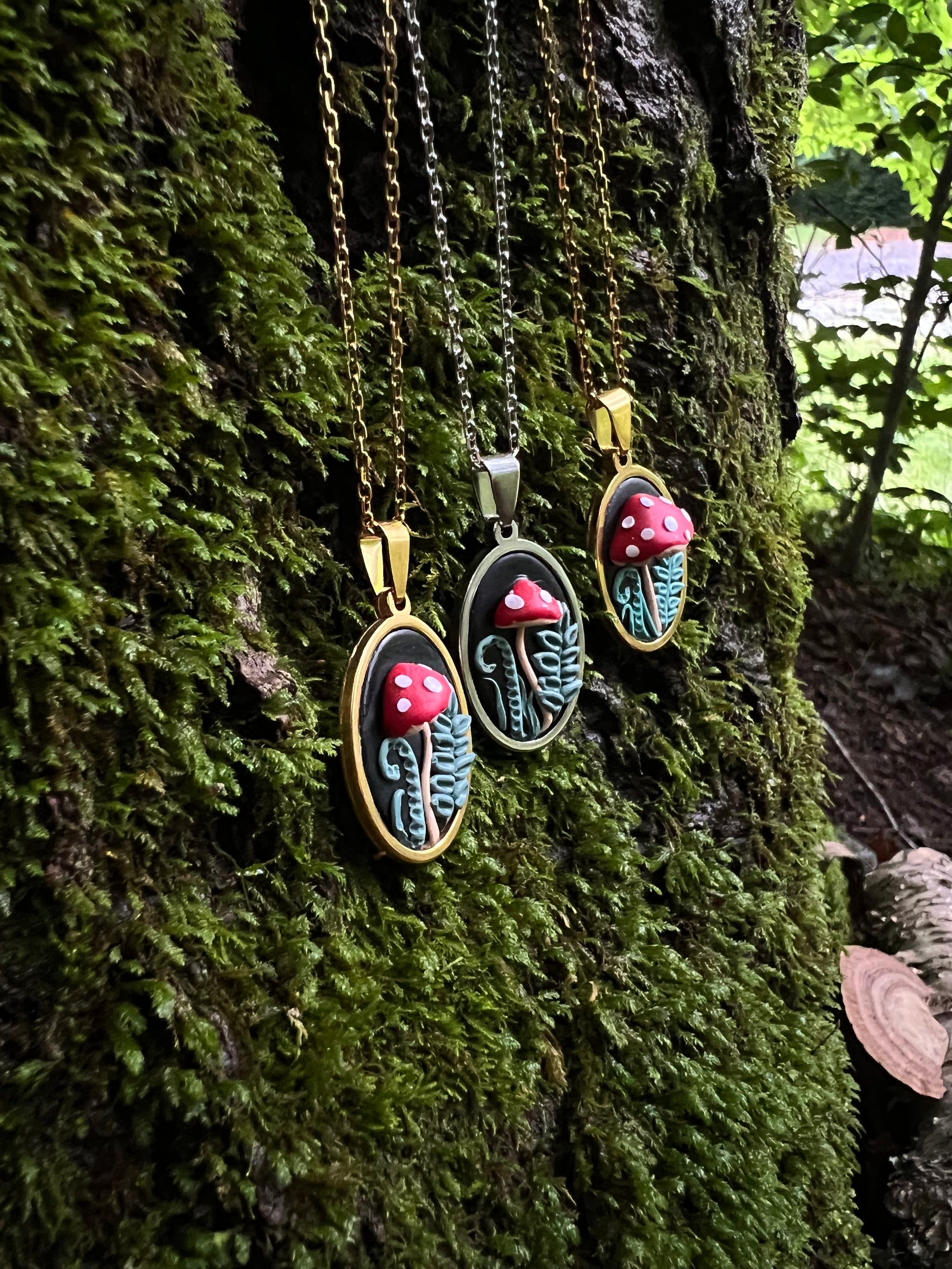 Three mushroom necklaces on a mossy surface