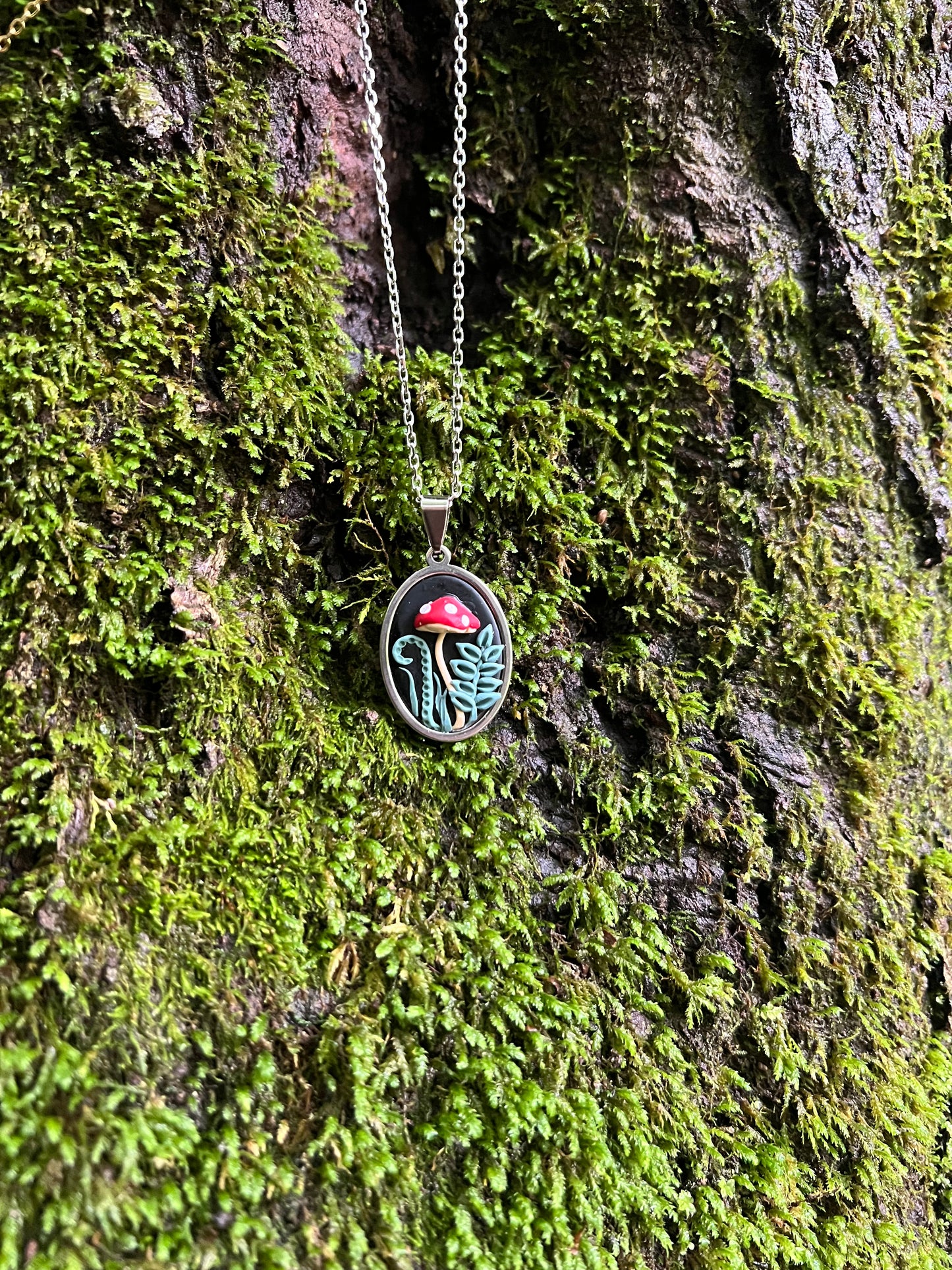 Necklace with a mushroom pendant on a mossy surface