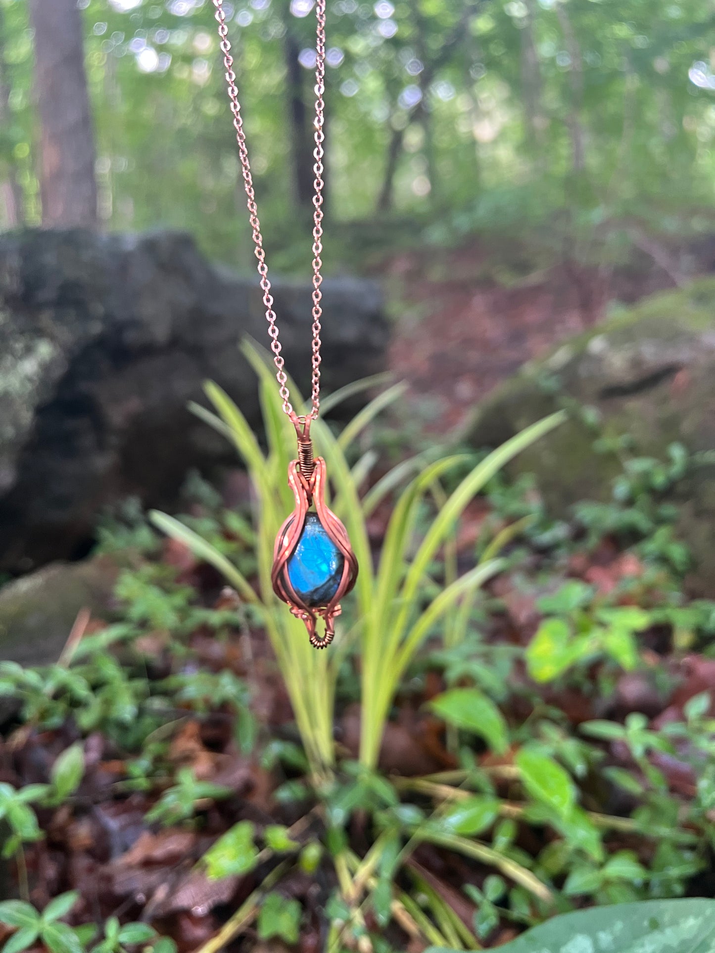 Necklace with a blue stone pendant against a natural background