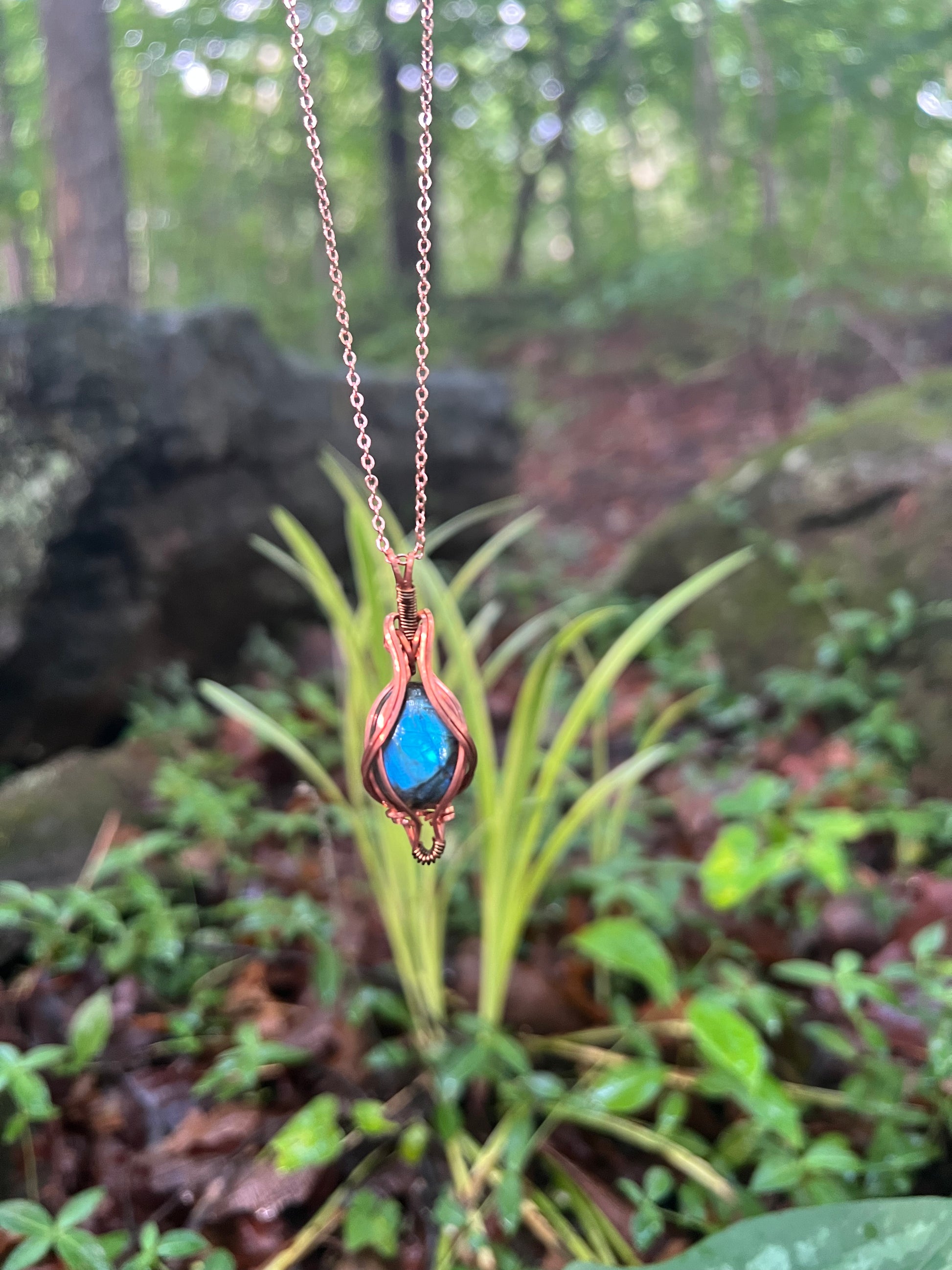 Necklace with a blue stone pendant against a natural background