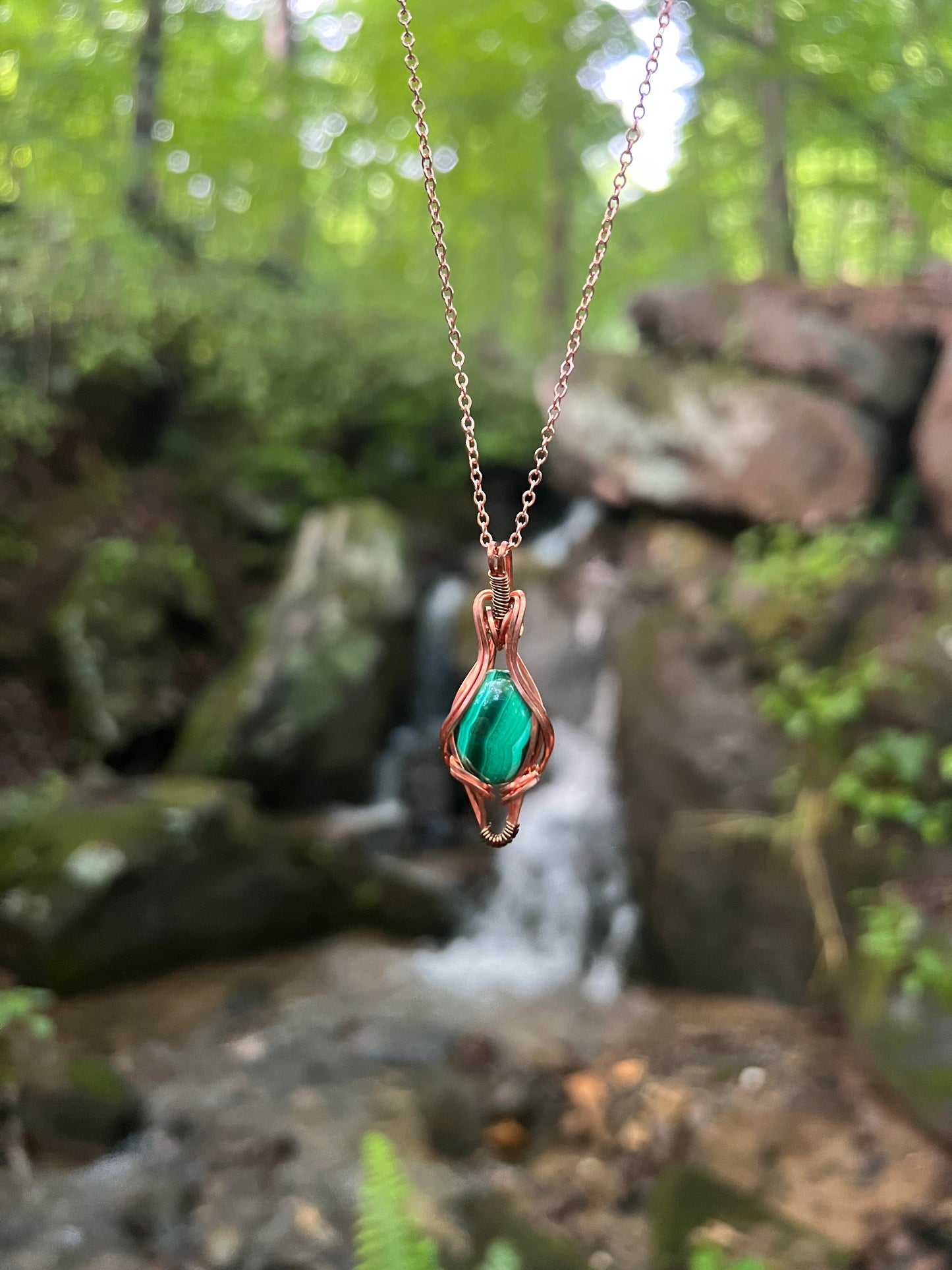 Wire Wrapped Malachite and Copper Necklace against a natural background