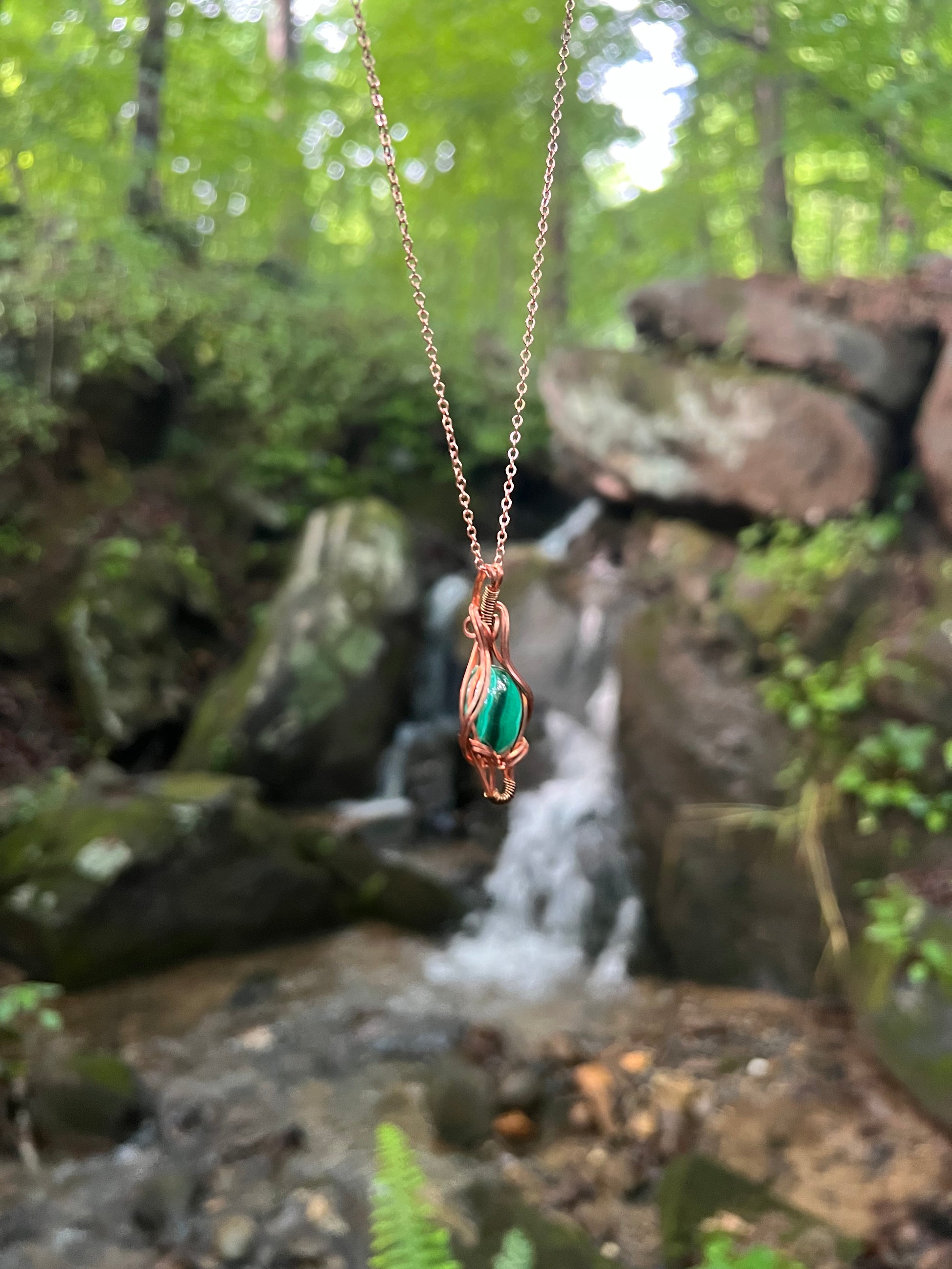 Wire Wrapped Malachite and Copper Necklace against a natural background