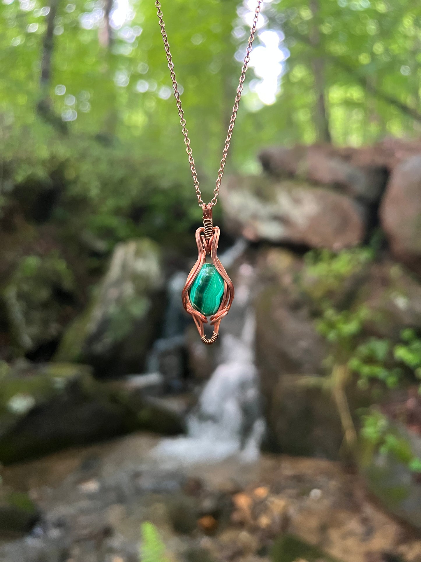 Wire Wrapped Malachite and Copper Necklace against a natural background