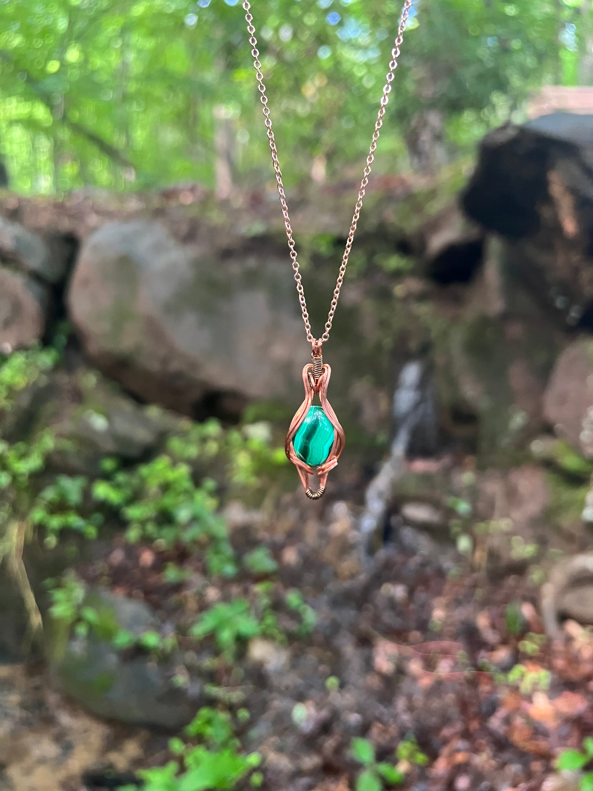 Wire Wrapped Malachite and Copper Necklace against a natural background