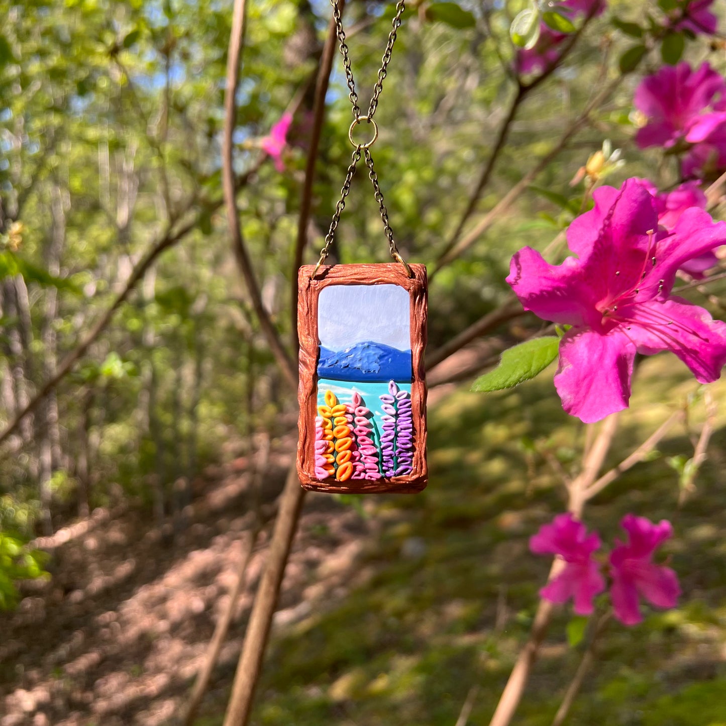 Hand-Sculpted Polymer Clay Necklace with Mountains a lake, and foxglove flowers 